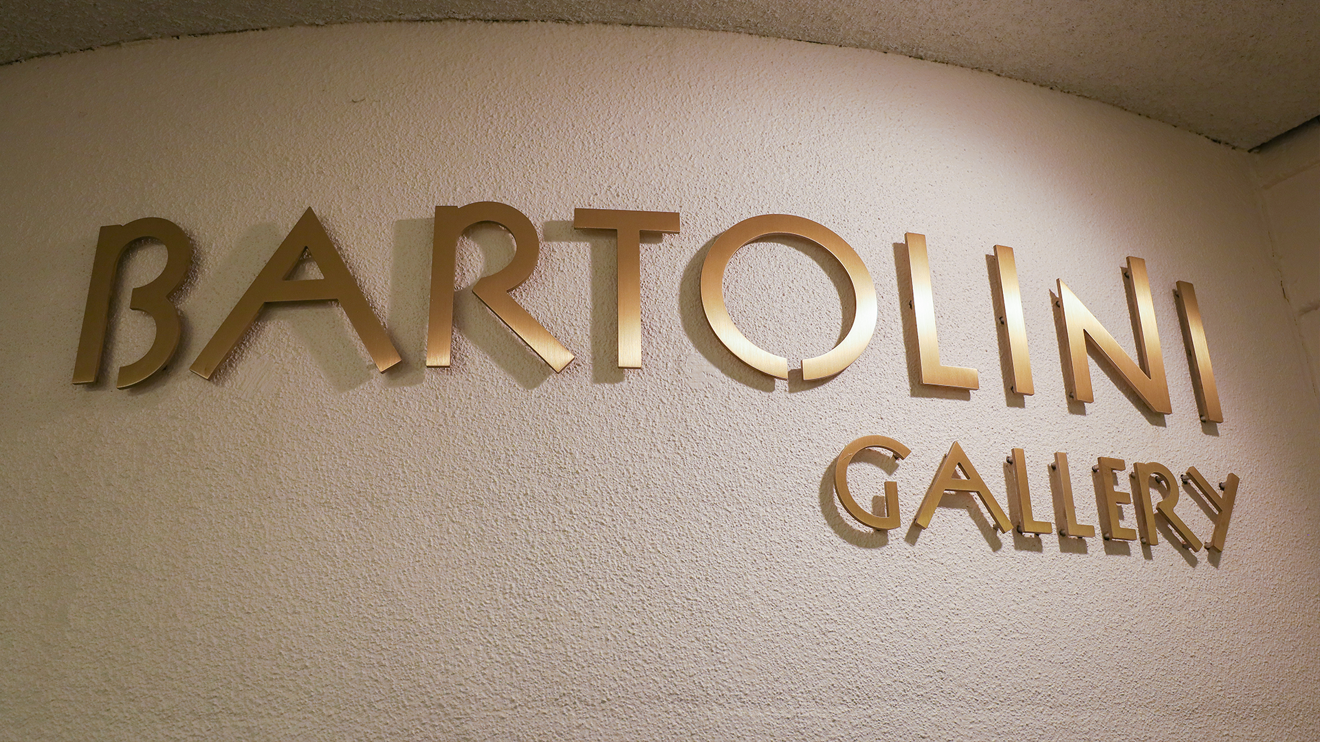 Bartolini Gallery sign on a stucco wall.
