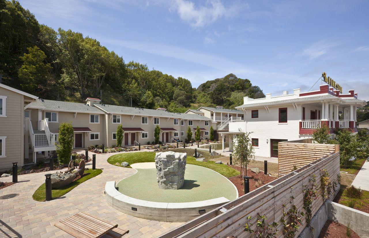 Two level apartments surrounding open space with pathways and gardens.