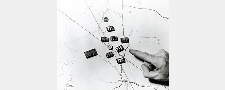 A map showing the location of 6 fire crews. A finger points to one of the crew locations. Black and white photo.