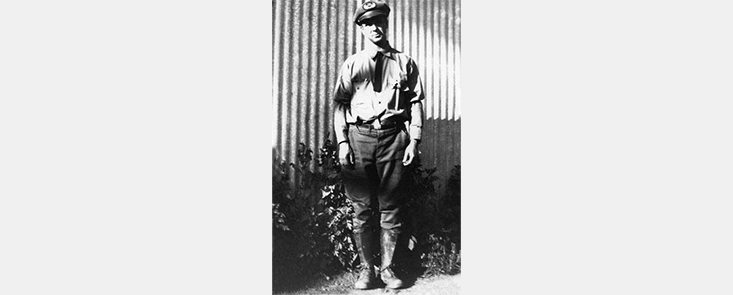 Portrait of a man in a fire uniform in front of a building. Black and white photo.