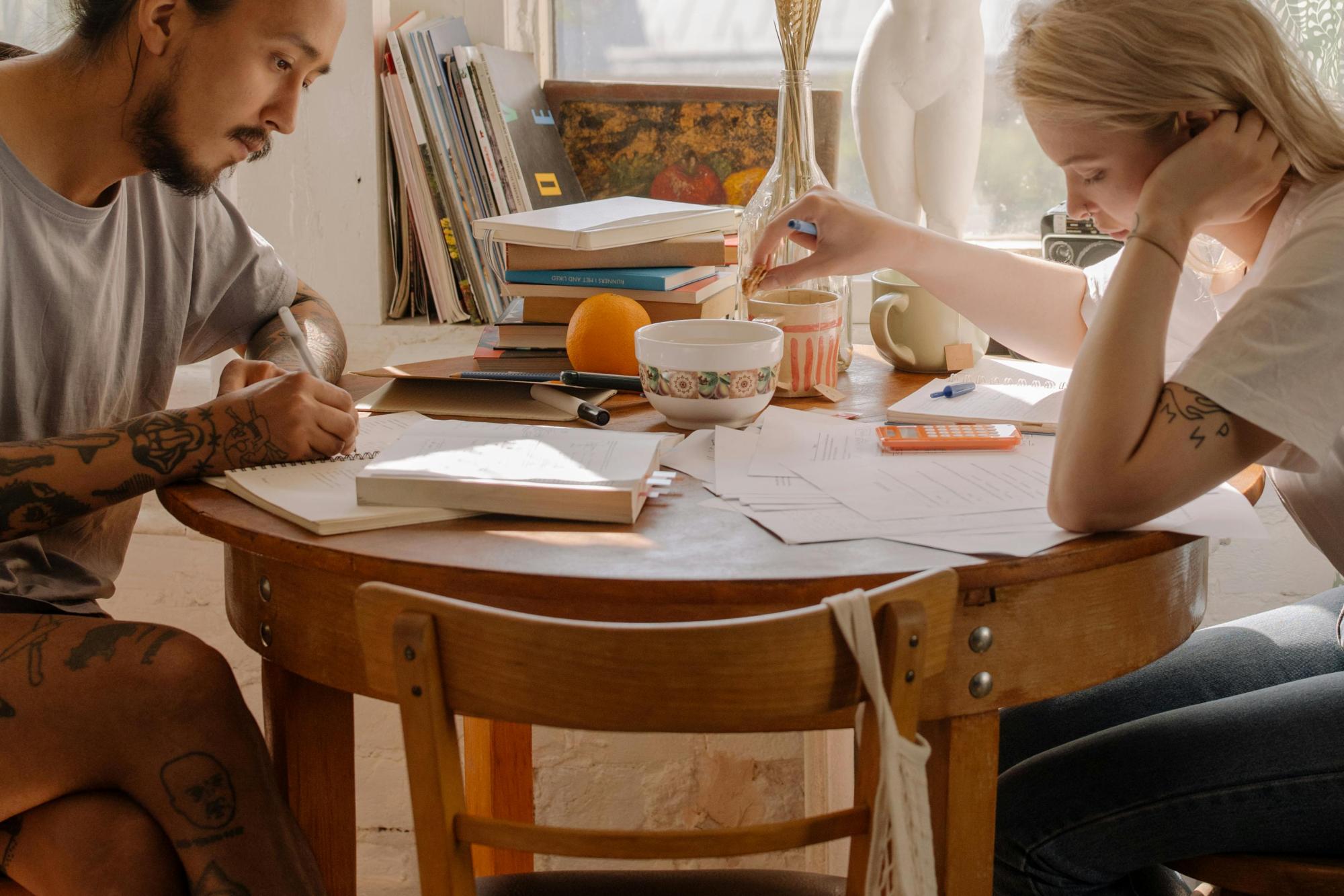 Two people at a table in their home, reviewing papers and plans.