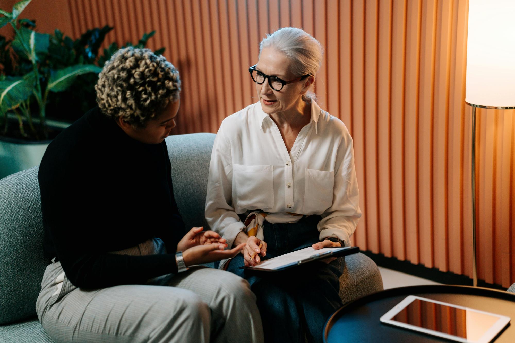 Two people on a couch discussing a business plan.