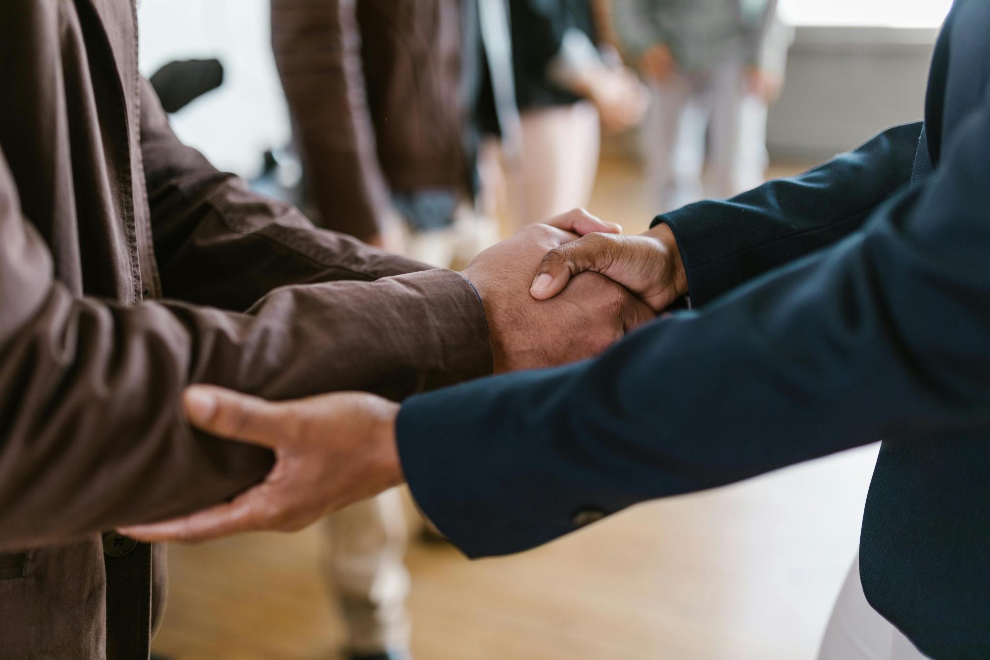 Two people shaking hands, symbolizing a business agreement.