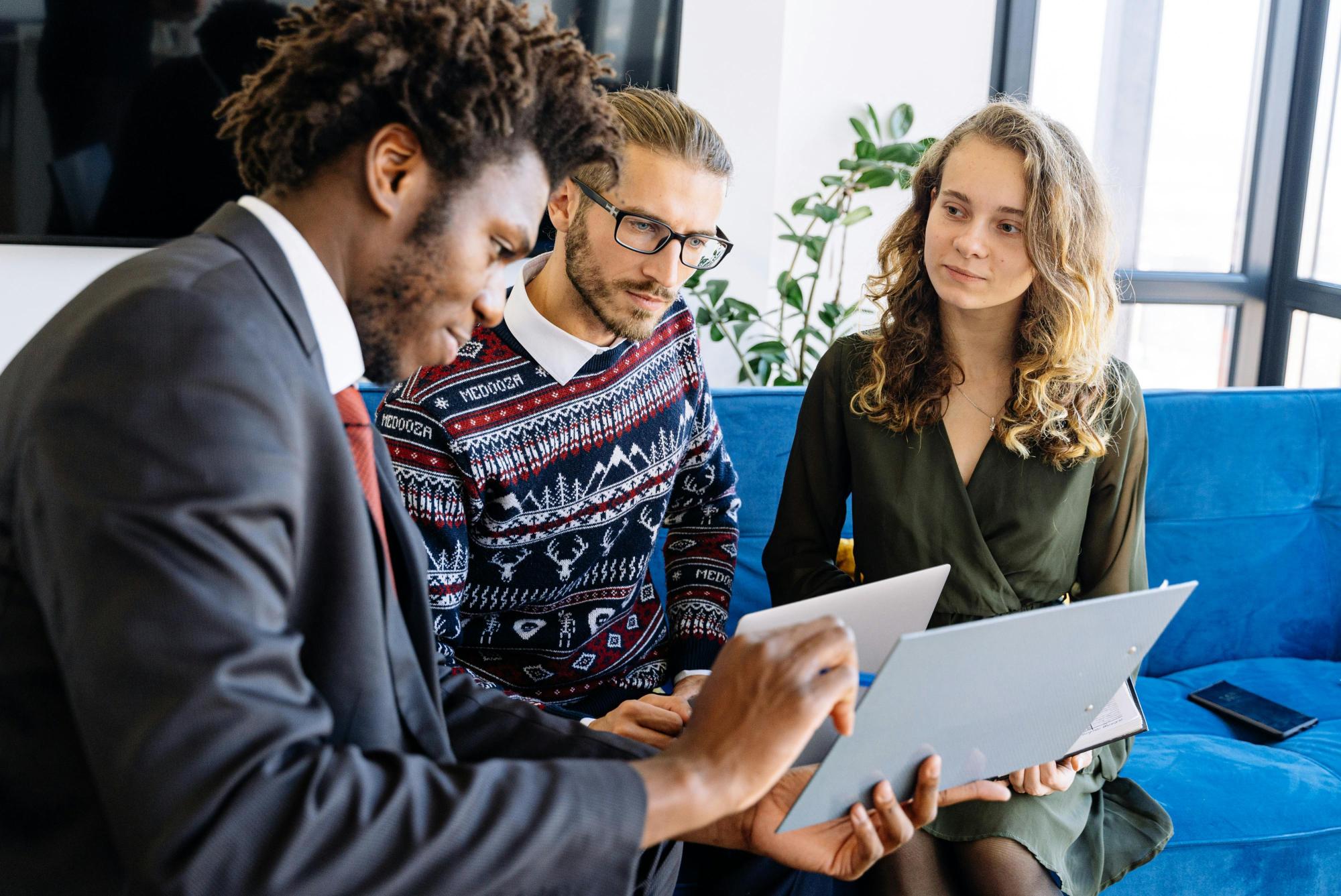 Three people reviewing financial data on papers, analyzing the figures.