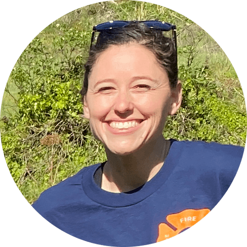 A headshot of a woman in a Marin County Fire Department t-shirt standing outside.