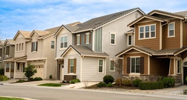 Row of modern two-story suburban homes along a quiet residential street.