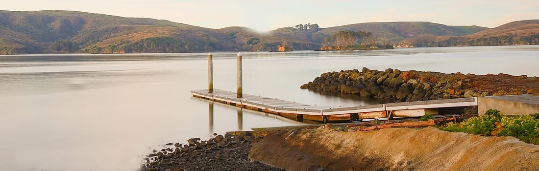 Boat launch ramp with mountains in the background.