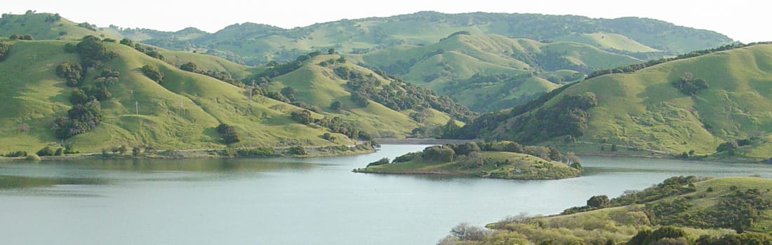 Lake with rolling green hills.