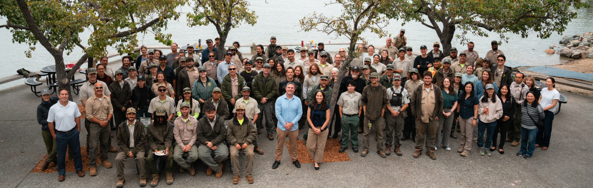 All staff standing in front of water.
