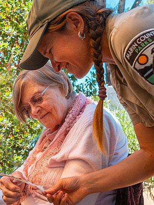Nursery coodinator with a visiting senior at a community grant event