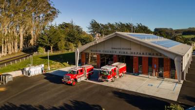 Fire station with fire trucks in front.